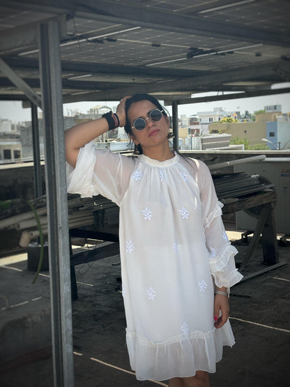 Adaa off-white Chikankari ruffle mini dress — lifestyle casually leaning against a column, personal occasion wear