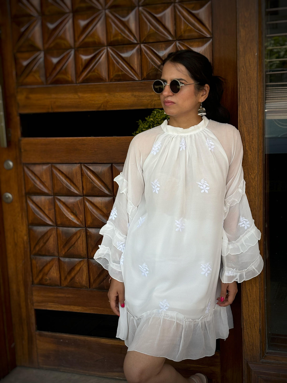 Adaa off-white Chikankari ruffle mini dress — lifestyle standing in front of door, personal occasion wear